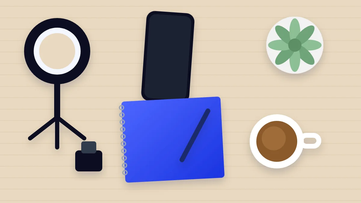 Top-down desk with a ring light, phone, blue notebook and coffee for planning videos